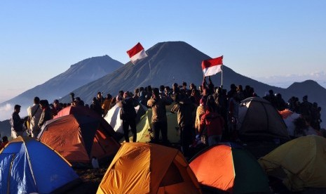  Pendaki mengibarkan bendera merah putih sambil menyanyikan lagu Indonesia Raya saat merayakan HUT RI ke-69 di puncak Gunung Prau kawasan datran tinggi Dieng Kejajar, Wonosobo, Jawa Tengah, Ahad (17/8).  (Antara/Anis Efizudin)