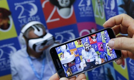 Seorang pengunjung memotret orang yang mencoba perangkat baru Samsung Gear VR di pameran teknologi konsumen IFA di Berlin, Jumat (5/9).    (Reuters / Fabrizio Bensch )