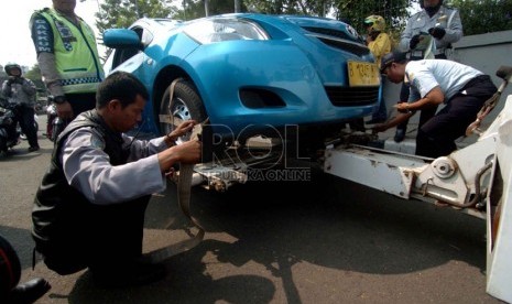  Petugas dari Dinas Perhubungan melakukan penertiban mobil taksi yang parkir sembarangan di kawasan Kalibata, Jakarta Selatan, Senin (8/9). (Republika/Raisan Al Farisi)