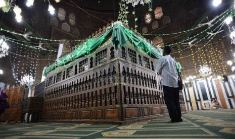 Terdapat dekorasi perahu di atas kubah makam Imam Syafii. Peziarah melihat makam Imam Syafi’i di Kairo, Mesir, Selasa (9/9). 