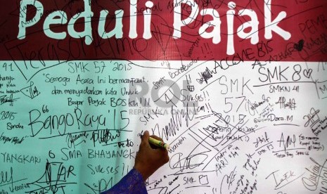   Sejumlah siswa membubuhkan tanda tangan Generasi Muda Peduli Pajak pada acara High School Tax Festival di Kantor Pelayanan Pajak (KPP) Pratama Pasar Minggu, Jakarta Selatan, Kamis (11/9). (Republika/ Yasin Habibi)