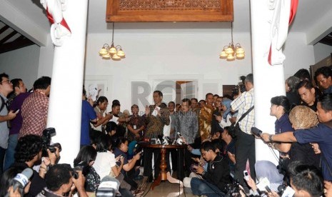   Presiden dan wakil presiden terpilih Joko Widodo dan Jusuf Kalla menggelar konferensi pers di Rumah Transisi, Jakarta, Senin (15/9). (Republika/ Wihdan)