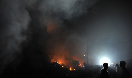 Sejumlah warga berusaha memadamkan api saat terjadi kebakaran pasar Hartaco Makassar, Sulsel, Selasa (16/9) malam.  (Antara/Yusran Uccang)