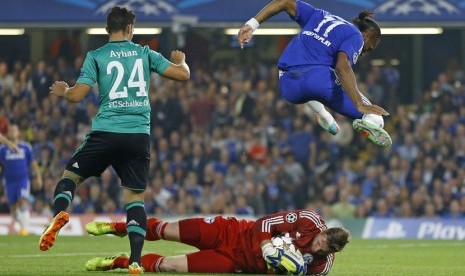  Pemain Chelsea Didier Drogba melompat di atas penjaga gawang Schalke Ralf Faehrmann di Stadion Stamford Bridge, London, Rabu (17/9). (AP/Kirsty Wigglesworth)