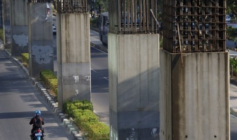 Pengendara melintasi tiang pancang monorel yang mangkrak di Jalan Rasuna Said Jakarta, Jumat (19/9).   (Antara/Wahyu Putro )