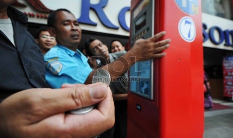  Seorang juru parkir memandu pengendara saat mengoperasikan mesin parkir meter di Jalan Sabang, Jakarta Pusat, Selasa (30/9).  (Republika/Rakhmawaty La'lang) 