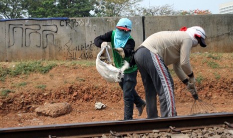 Para pekerja sedang mengambil batu untuk penaikan rel kereta api di perlintasan rel kereta api Stasiun Sudirman, Jakarta, Selasa (30/9). ( foto: mgROL30)