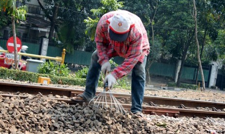   Para pekerja sedang menarik batu untuk penaikan rel kereta api di perlintasan rel kereta api Stasiun Sudirman, Jakarta, Selasa (30/9). (foto : mgROL30)