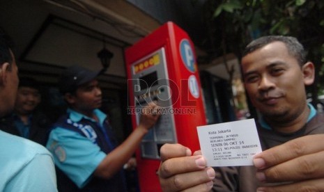   Pengendara menunjukkan tiket karcis parkir setelah melakukan transaksi dalam mesin parkir meter di Jalan Sabang, Jakarta Pusat, Senin (6/10). (Republika/Raisan Al Farisi)