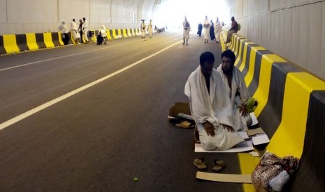  Dua jamaah haji shalat di pinggir jalan di dalam terowongan King Fahd yang menuju arah Mina, Sabtu (4/10) siang waktu Arab Saudi.(Republika/Zaky Al Hamzah)