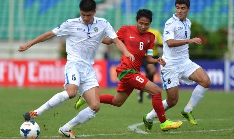   Pesepakbola timnas U-19 Indonesia Evan Dimas (tengah) diapit pesepakbola timnas U-19 Uzbekistan Hambrobekov Odiljon (kiri) dan Sokhibov Javokhir (kanan) di Stadion Thuwunna Youth Training Center Yangon, Myanmar, Jumat (10/10).(Antara/Andika Wahyu)