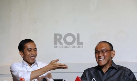   Presiden terpilih Joko Widodo (kiri) bersama Ketua Umum Partai Golkar Aburizal Bakrie (kanan) usai melakukan pertemuan tertutup di Jakarta, Selasa (14/10). (Republika/ Tahta Aidilla)