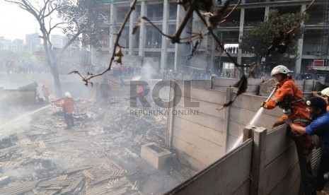    Petugas pemadam kebakaran berusaha memadamkan api yang melahap mess pekerja di Gang Jangkrik, Jalan Guru Mukni, Semanggi, Jakarta Selatan, Selasa (14/10). (Republika/Raisan Al Farisi)