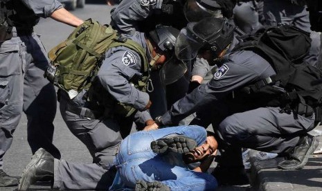   Polisi Israel menahan seorang pengunjuk rasa warga Palestina saat memprotes peziarah yahudi yang masuk ke dalam Komplek Masjid Al Aqsa di Jerusalem, Rabu (15/10). (Reuters/Ammar Awad)