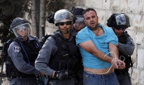   Polisi Israel menahan seorang pengunjuk rasa warga Palestina saat memprotes peziarah yahudi yang masuk ke dalam Komplek Masjid Al Aqsa di Jerusalem, Rabu (15/10). (Reuters/Ammar Awad)