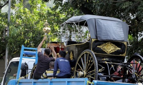  Pekerja membawa kereta kencana mengunakan mobil bak terbuka melintas dikawasan Monas, Jakarta, Ahad (19/10). (Antara/Muhammad Adimaja)