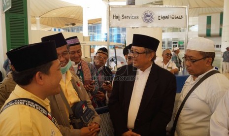 Ketua Komisi Pengawas Haji Indonesia (KPHI) Slamet Effendy Yusuf (berjas hitam) berbincang dengan jamaah haji Kloter 20 Embarkasi Surabaya di ruang tunggu Bandara Internasional King Abdul Aziz, Jeddah, Arab Saudi, Jumat (15/10). (Republika/Zaky al Hamzah)