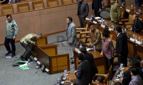   Ketua Fraksi PPP Hasrul Azwar (kiri) meninggalkan ruang rapat usai membalik meja rapat saat rapat paripurna terkait pengesahan alat kelengkapan dewan (AKD) di Gedung Nusantara II, DPR, Jakarta, Selasa (28/10).  (Republika/Agung Supriyanto)