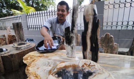  Pedagang fosil kayu, Wawan (31) menjajakan dagangannya di kawasan Kemang Dalam, Jakarta Selatan, Senin (3/11).   (Republika/Raisan Al Farisi)