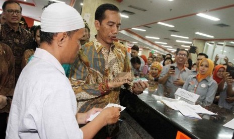  Presiden Joko Widodo memberi Kartu Indonesia Sehat (KIS), Kartu Indonesia Pintar (KIP) dan Kartu Keluarga Sejahtera (KKS) secara simbolis pada warga yang berhak di Kantor Pos Besar, Jakarta Pusat, Senin (3/11). (Republika/ Yasin Habibi)