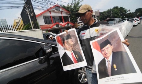   Seorang pedagang menjajakan poster Presiden Joko Widodo dan Wakil Presiden Jusuf Kalla di Kawasan Menteng, Jakarta Pusat, Senin (3/11). ( Republika/Raisan Al Farisi)