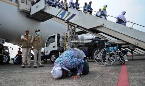 Jamaah haji melakukan sujud syukur saat tiba di Bandara Halim Perdana Kusuma, Jakarta, Rabu (5/11). (Republika/Tahta Aidilla)