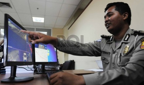   Petugas operator melakukan pemantauan lewat monitor CCTV saat uji coba pemberlakukan tilang elktronik di kantor National Traffic Management Centre (NTMC), Jakarta, Ahad (9/11).(Republika/Rakhmawaty La'lang )