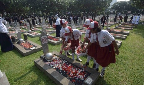    Sejumlah siswa melakukan tabur bunga ke sejumlah makam pahlawan usai Upacara Ziarah Nasional di Taman Makam Pahlawan Nasional, Kalibata, Jakarta, Senin (10/11). (Republika/Agung Supriyanto)