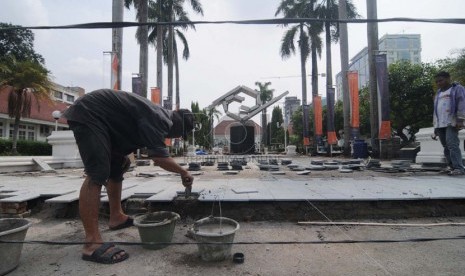  Pekerja menyelesaikan pekerjaan renovasi bagian taman di halaman Galeri Nasional, Jakarta Pusat, Selasa (11/11). ( Republika/Raisan Al Farisi)