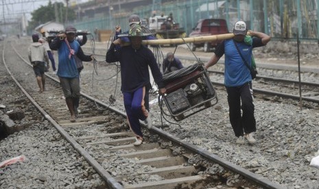  Pekerja membawa alat yang digunakan untuk memperbaiki rel kereta api di Kawasan Pademangan, Jakarta Utara, Selasa (11/11). (Antara/Wahyu Putro A)