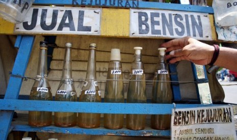  Abdul Mukti (56) menata botol-botol yang berisi BBM jenis Premium (bensin) di kios bensin kejujuran di Jalan Raya Veteran, Kota Kediri, Jawa Timur, Selasa (18/11).  (Antara/Rudi Mulya)