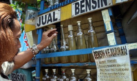  Abdul Mukti (56) menata botol-botol yang berisi BBM jenis Premium (bensin) di kios bensin kejujuran di Jalan Raya Veteran, Kota Kediri, Jawa Timur, Selasa (18/11).  (Antara/Rudi Mulya)