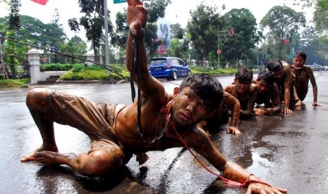 Pengunjukrasa dari Gerakan Mahasiswa Nasional Indonesia (GMNI) melakukan aksi teatrikal menyikapi kenaikan BBM di jalan Dipenogoro, Bandung, Jawa Barat, Selasa (18/11).   (Antara/Agus Bebeng)