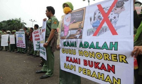  Guru honorer yang tergabung dalam Front Pembela Honorer Indonesia (FPHI) berunjuk rasa di depan Komplek Parlemen, Senayan, Jakarta, Senin (1/12).  (Republika/Agung Supriyanto)