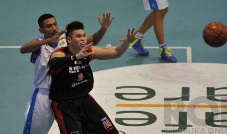 Center Aspac Jakarta Ferdinand Damanik (kanan) menerima umpang dibayang-bayangi pemain Bimasakti Nikko Steel Malang dalam laga seri I Liga Basket NBL 2014 di Senayan, Jakarta, Rabu (3/12). 