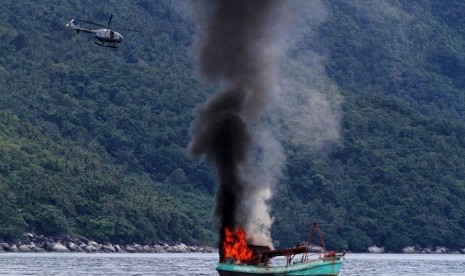   Kapal ikan asing asal Vietnam diledakkan dan ditenggelamkan oleh TNI Angkatan Laut di perairan Natuna, Kepulauan Riau, Jumat (5/12). (Antara/Immanuel Antonius)