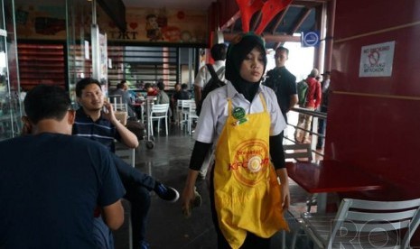  Pekerja sebuah restoran cepat saji di Banten, Ahad (7/12), mengenakan atribut Natal berupa tanduk rusa sebagai bagian seragamnya. 