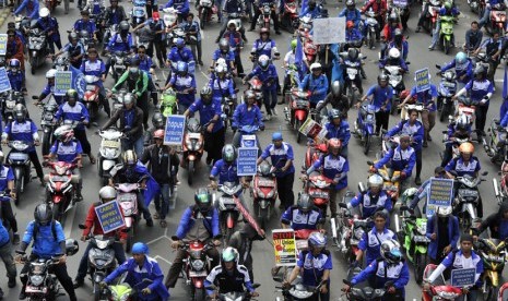   Massa buruh mendorong motor mereka ketika berunjuk rasa di Jalan MH. Thamrin, Jakarta Pusat, Rabu (10/12).  (Antara/Andika Wahyu)