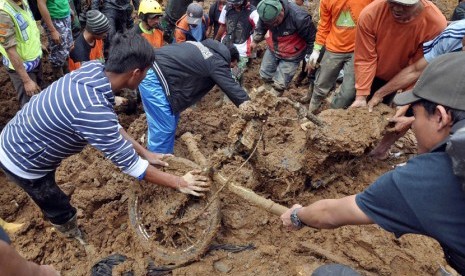  Warga mengevakuasi bangkai sepeda motor yang tertimbun tanah longsor di Dusun Jemblung, Desa Sampang, Kecamatan Karangkobar, Banjarnegara, Jawa Tengah, Sabtu (13/12).(Antara/Anis Efizudin)