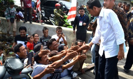 Presiden Joko Widodo berjabat tangan dengan warga  saat tiba  di Desa Sei Pancang Kecamatan Sebatik Utara, di pintu masuk Pos TNI AL Pulau Sebatik Kabupaten Nunukan, Kalimantan Utara, Selasa (16/12). (Antara/M Rusman)