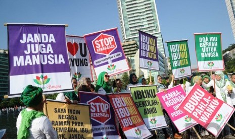  Aktifis tergabung dalam Perempuan Bangsa membawa poster saat melakukan aksi peringatan Hari Ibu di Bundaran HI, Jakarta, Ahad (21/12). (Republika/Tahta Aidilla)