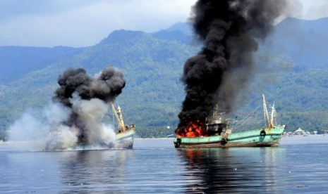 Dua kapal ikan ilegal berbendera Papua Nugini meledak dan mengeluarkan api ketika ditenggelamkan personel Lantamal IX Ambon di Perairan Teluk Ambon, Maluku, Ahad (21/12). (Antara/Izaac Mulyawan)