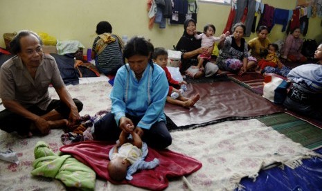   Warga korban banjir berada di tempat pengungsian di Gedung Juang, Baleendah, Kabupaten Bandung, Jawa Barat, Ahad (21/12). (Antara/Novrian Arbi)