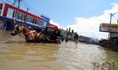    Sejumlah warga melintasi banjir di Jalan Dayeuhkolot, Kabupaten Bandung, Kamis(25/12).  (foto: Septianjar Muharam)