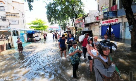 Sejumlah warga melintasi banjir di Jalan Dayeuhkolot, Kabupaten Bandung.  (foto: Septianjar Muharam)