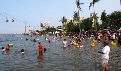 Warga Jakarta dan sekitarnya mengisi liburan dengan berenang di Pantai Festival Taman Impian Jaya Ancol (TIJA), Jakarta, Kamis (25/12). (Republika/Agung Supriyanto)