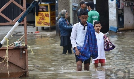  Sejumlah anak bergegas untuk memasuki Masjid Agung Dayeuh Kolot guna menunaikan Ibadah Shalat Jumat saat banjir melanda Bandung Selatan, Jumat (26/12).  (Republika/Raisan Al Farisi)