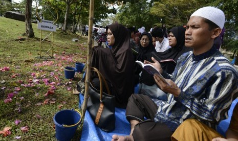 Warga memanjatkan doa di pemakaman massal korban tsunami Ule Lheu, Banda Aceh. 