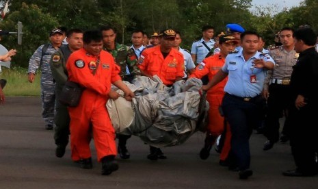    Sejumlah Tim SAR membawa serpihan pesawat Air Asia QZ 8501 yang ditemukan KRI Bung Tomo di Lanud Iskandar, Pangkalan Bun, Kalimantan Tengah, Selasa (30/12).  (Antara/Kenarel)