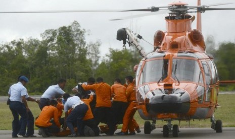  Anggota BASARNAS dibantu anggota TNI AU memindahkan jenazah korban kecelakaan pesawat Air Asia dari helikopter BASARNAS di Lanud Iskandar, Pangkalan Bun, Kalimantan Tengah, untuk dibawa ke RSUD Sultan Imanudin, Rabu (31/12). (Antara/Fanny Octavianus)